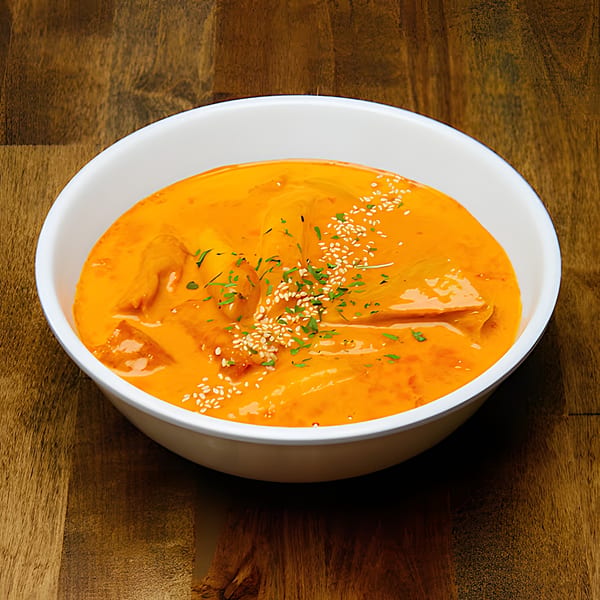 Dagiya's Korean tteokbokki, a spicy rice cake dish, garnished with sesame seeds and herbs.